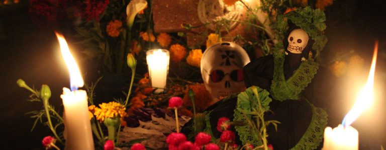 Mantienen tradiciones en panteones con flores, comida y música